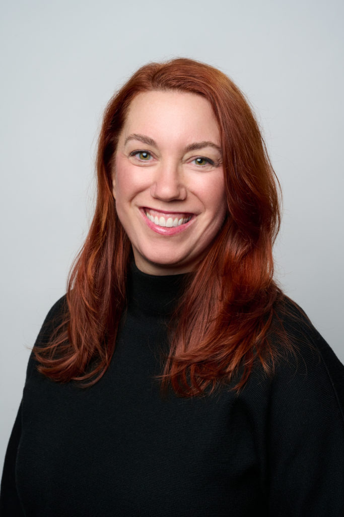 Photograph of Joanna Russell Bliss, a white woman with red hair, wearing a black sweater